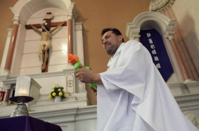 Απίστευτο: Ιερέας-μπάτμαν ψεκάζει αγιασμό με...νεροπίστολο (pics)