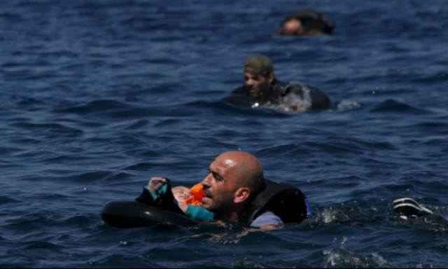 Συγκλονιστικές φωτογραφίες: Πρόσφυγας κολυμπάει με μωρό στην αγκαλιά του