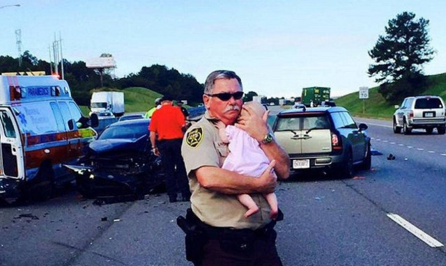 Αστυνομικός παρηγορεί βρέφος μετά από αυτοκινητιστικό ατύχημα