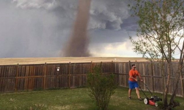 Απίστευτο: Κούρευε αμέριμνος το γκαζόν και πίσω του περνούσε... ανεμοστρόβιλος! (vid)