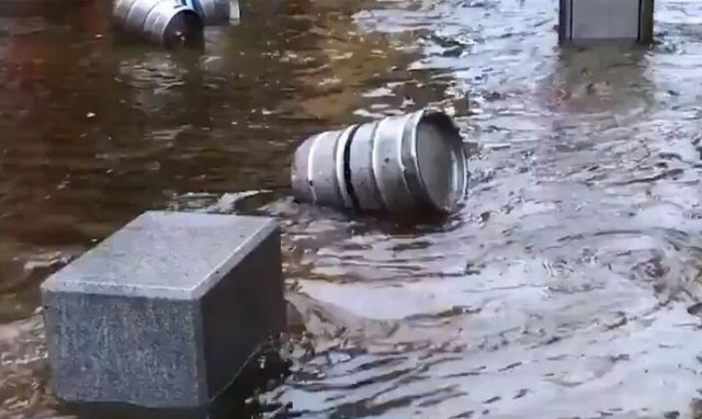 Οι δρόμοι έγιναν ποτάμια από τις πλημμύρες και γέμισαν με βαρέλια μπίρας