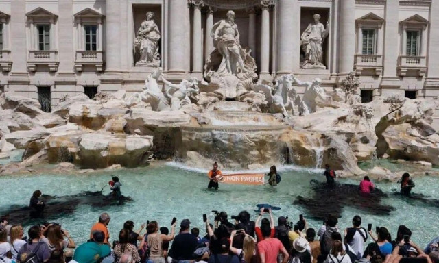 Ρώμη: Ακτιβιστές έβαψαν μαύρη τη Φοντάνα ντι Τρέβι - Τους έβγαλαν σηκωτούς από το συντριβάνι