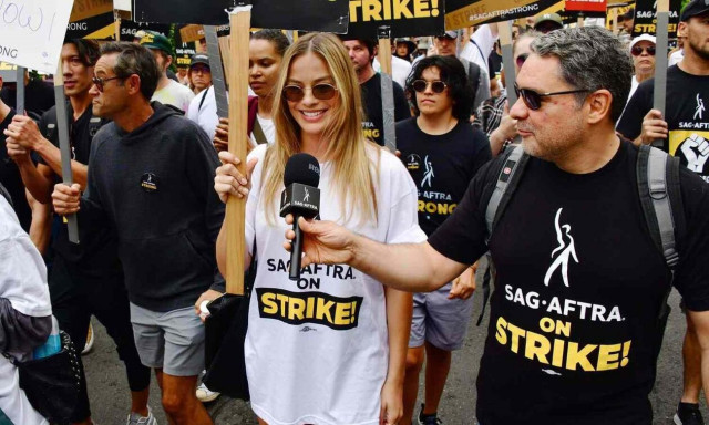 Μάργκοτ Ρόμπι: Η κινηματογραφική Barbie με πλακάτ σε πορεία ηθοποιών στο Χόλιγουντ