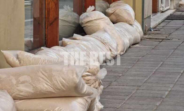 Κακοκαιρία – Πάτρα: Μαγαζάτορες βάζουν τσουβάλια με άμμο για να «οχυρώσουν» τις επιχειρήσεις τους