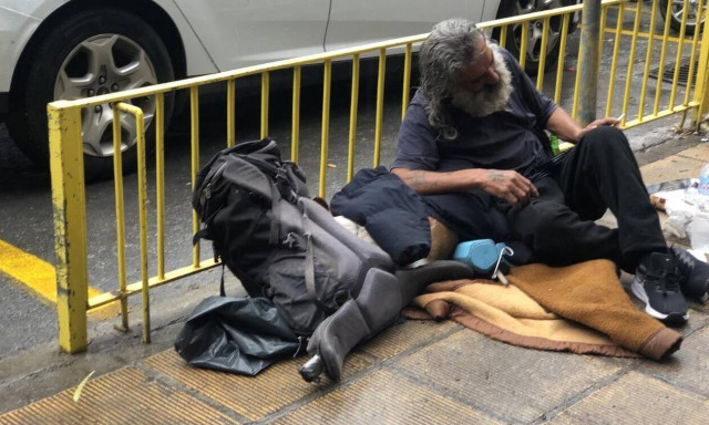 Άστεγος στο Ηράκλειο βγάζει το μπουφάν του στη βροχή για να σκεπάσει το σκυλί του