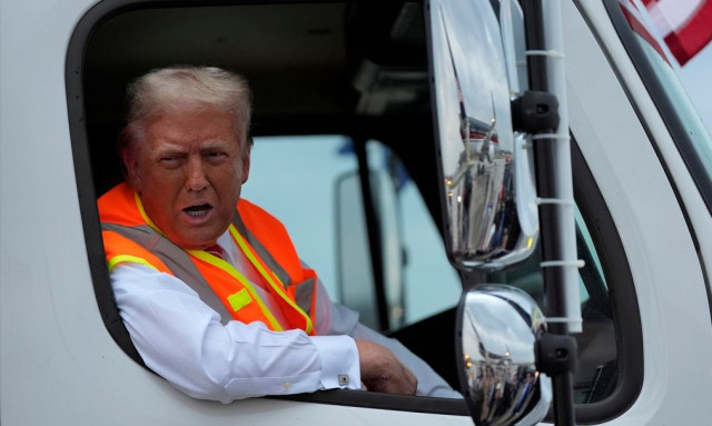 Tραμπ: «Οδήγησε» απορριματοφόρο και φόρεσε πορτοκαλί γιλέκο για να τρολάρει τον Μπάιντεν