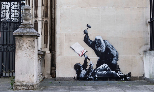 Αναστάτωσε το νέο έργο του Banksy: Δικαστής σφυροκοπά διαδηλωτή - Κάλυψαν άρον άρον το γκράφιτι