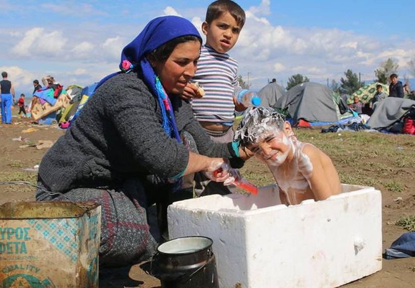 Συγκλονιστική φωτογραφία από την Ειδομένη: Προσφυγόπουλα κάνουν μπάνιο σε κουτί από φελιζόλ