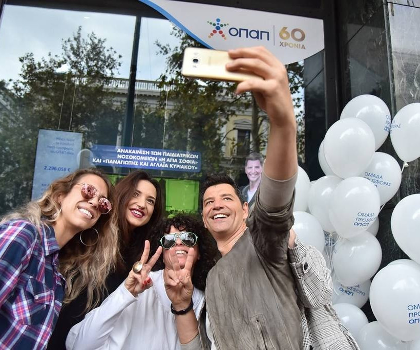 O Σάκης Ρουβάς φωτογραφίζεται με μέλη της ομάδας προσφοράς ΟΠΑΠ