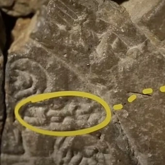 a yellow circle with a line drawn on a rock