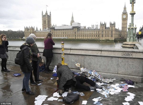 3E87554E00000578 4338998 A woman leans down on Westminster Bridge to help another woman w a 1 1490219423721