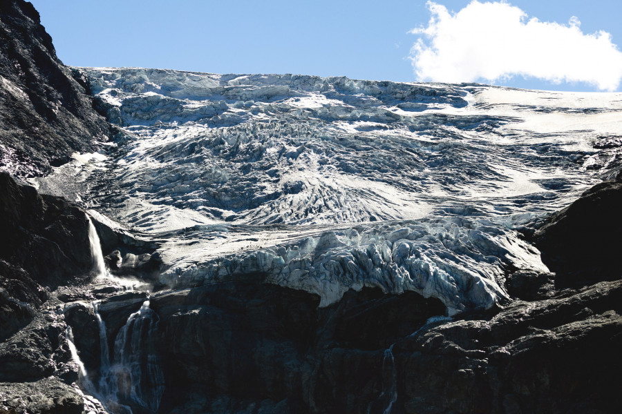 A view shows water from melting ice running down the side of the Turtmann glacier on a warm summer day, in Turtmann