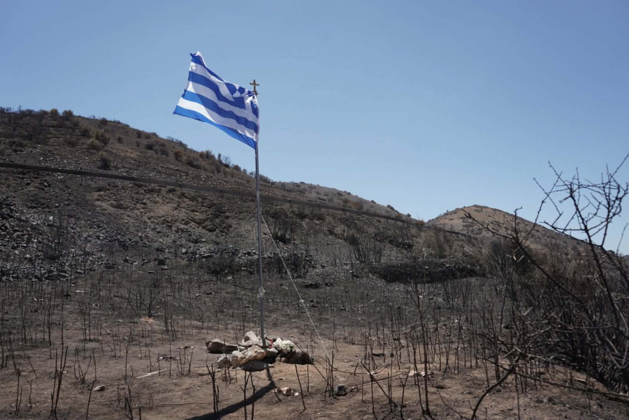 Ρέθυμνο: Η ελληνική σημαία στο σημείο που χάθηκαν οι δύο πυροσβέστες στην Κρύα Βρύση.