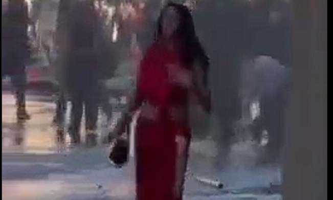 «Η γυναίκα με τα κόκκινα»: Η στιγμή που κανόνι νερού εκτοξεύει στον «αέρα» ανέμελη διαδηλώτρια