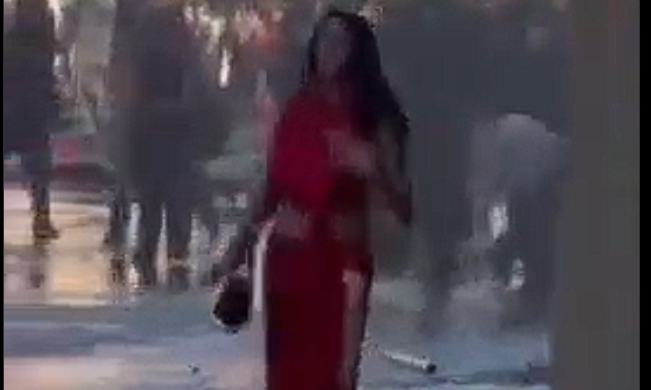 «Η γυναίκα με τα κόκκινα»: Η στιγμή που κανόνι νερού εκτοξεύει στον «αέρα» ανέμελη διαδηλώτρια